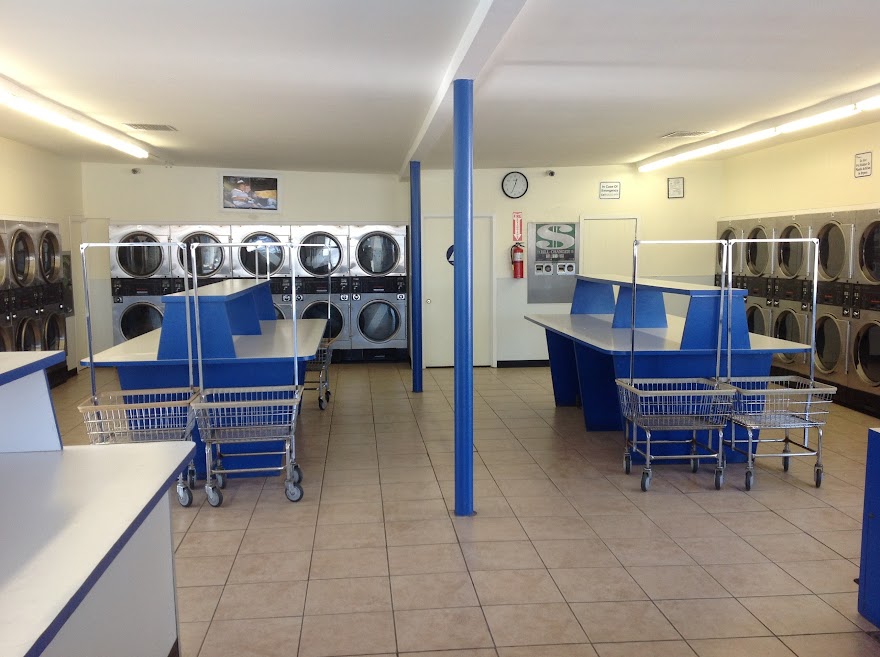 ECP Coin Laundry El Monte interior showing commercial washers and dryers with blue and white color scheme and folding tables