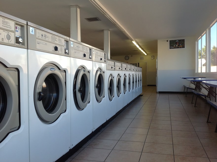ECP Coin Laundry El Monte showing long row of commercial washing machines with folding area and clean tile floors